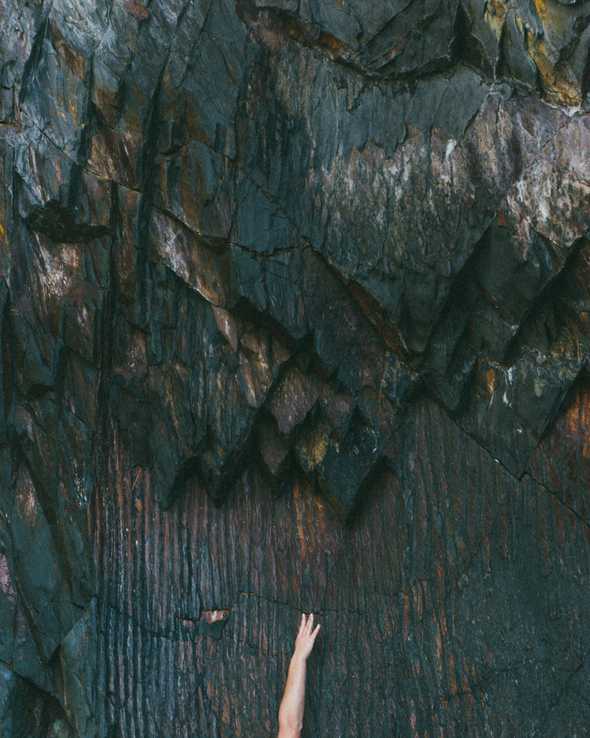 A hand tring to reach new level on a stone wall A hand tring to reach new level on a stone wall
